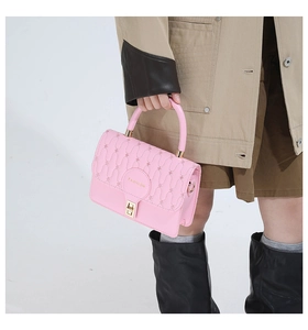 Detail of pink quilted handbag with gold metal clasp and Fashion embossed logo