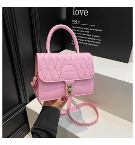 Detailed view of pink quilted handbag with gold clasp and elegant handle