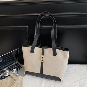 Minimalist canvas tote bag with black leather trim and gold buckle for office use