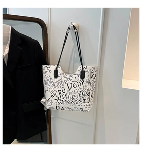 Dettaglio borsa shopper bianca con graffiti neri artistici su una parete bianca