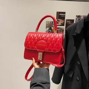 Elegant red square handbag with quilted pattern and gold twist lock in lifestyle setting