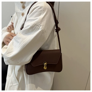 Dettaglio di una borsa a tracolla vintage in pelle testa di moro con chiusura dorata e nodo