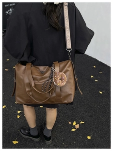Détail du sac cabas marron en similicuir avec bandoulière ethnique et pendentif
