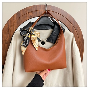 Detailed view of brown lychee leather hobo bag with vintage chain pattern silk scarf detail