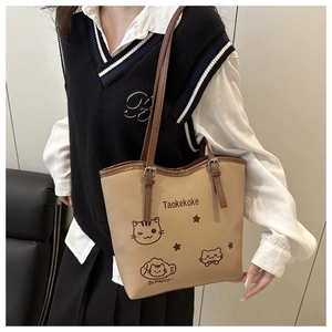 Detail of the cat illustration and adjustable contrast strap on the beige tote bag