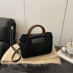 Chic black leopard faux fur crossbody bag with wooden handle on a cozy scarf