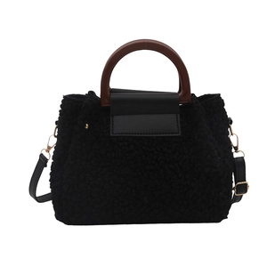 Chic black plush faux fur handbag with wooden handles and leather flap for winter