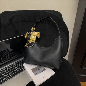 Chic black lychee texture hobo bag with printed silk scarf on a stylish office setting