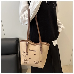 Detailed shoulder strap and cat illustration on large beige faux leather tote bag
