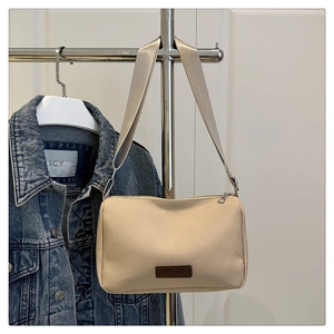 Vue détaillée du sac bandoulière en toile beige avec patch cuir et large bandoulière