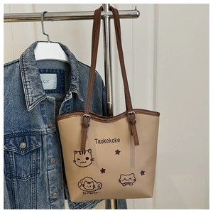 Detail of beige tote bag with cartoon cat print and brown adjustable shoulder strap
