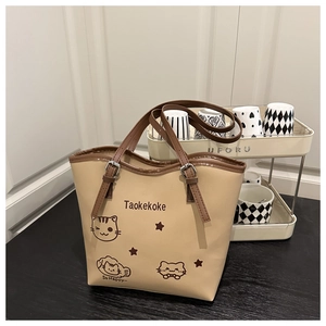 Detail of the cat print and adjustable metal buckles on the beige shoulder tote bag
