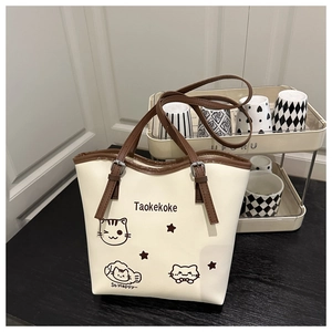 Detail of cartoon cat print tote bag with brown straps and adjustable metal buckle