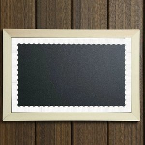 Tableau avec bordure en bois blanc et panneau à bords ondulés sur fond bois foncé