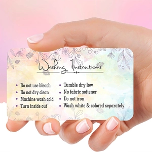 Floral watercolor garment care guide card featuring detailed laundry instructions