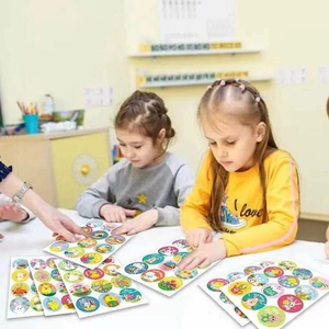 Kids playing with Happy Easter stickers featuring colorful rabbits and eggs patterns