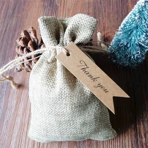 Jute drawstring gift bag with 'Thank you' kraft tag on rustic wood background
