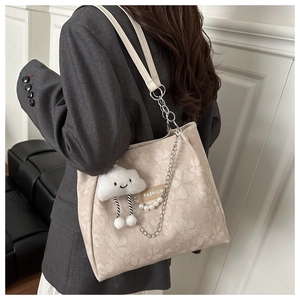 Détail du sac cabas beige en jacquard à fleurs avec charm peluche et chaîne perlée