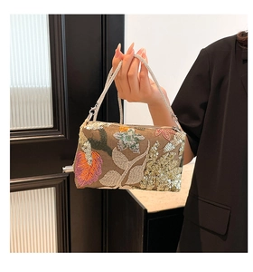 Detailed view of bohemian floral embroidery and sequins on a vintage handbag