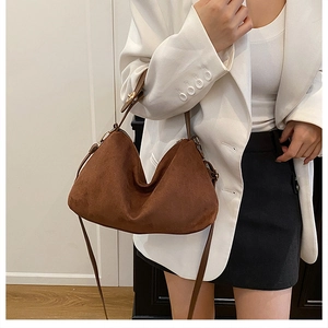 Detail of soft brown suede hobo bag with gold zipper and dual strap system