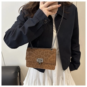 Detailansicht der braunen Umhängetasche mit Leopardenmuster und silberner Kette am Modell