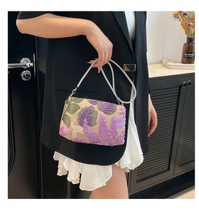 Detail of sequined floral embroidery on beige handbag with silver chain strap