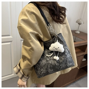 Détail du sac fourre-tout gris foncé avec bandoulière chaîne, perles et charme nuage peluche