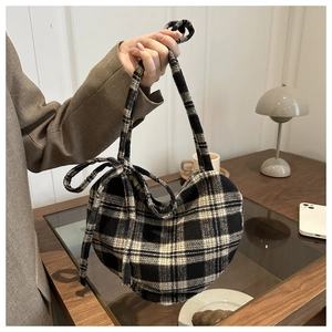 Λεπτομέρεια της vintage καρό τσάντας tote με διακοσμητικό πλαϊνό φιόγκο για το χειμώνα