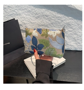 Detailed embroidery work with sequins and leaves on the crossbody bag flap