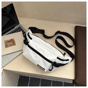 Gros plan d'un sac de poitrine en nylon blanc avec zips noirs sur un bureau en bois