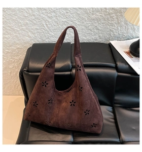 Detail of laser-cut petal pattern on dark brown faux suede shoulder tote bag