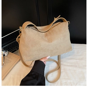 Detail of beige faux suede tote bag featuring smooth zipper and stylish double straps