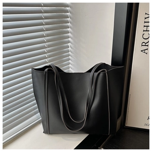 Detailed close-up of high-quality black PU leather texture on a large tote bag
