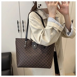 Detail of vintage monogram tote bag with leather buckle strap and shoulder wear style