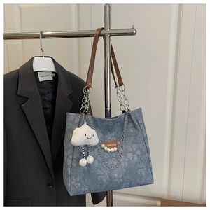 Bolso tote floral con correas de cuero marrón, cadenas plateadas y colgante de nube