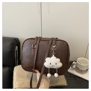 Detailed view of brown PU leather bowling bag featuring a cute white cloud plush charm