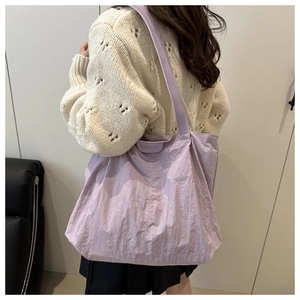 Détail d'un grand sac fourre-tout en nylon violet clair avec une large bandoulière