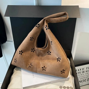 Brown suede tote bag with petal laser-cut design presented in a black gift box