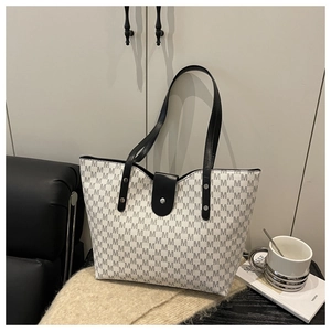 Detail of monogram pattern and leather buckle on large capacity tote shoulder bag