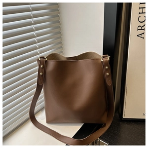 Detailed macro view of dark brown leather bucket bag texture with gold stud accents