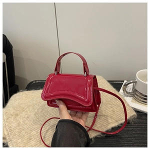 Détail du mini sac en cuir verni rouge brillant avec une finition élégante et texturée