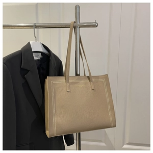 Detail shot of khaki lychee grain leather tote bag with elegant white stitching