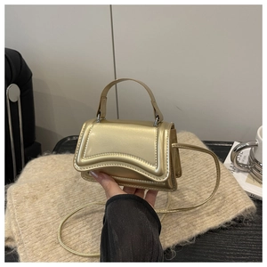 Détail du mini sac doré métallisé avec bords festonnés et fine bandoulière