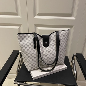 Large tote bag with M-pattern print and black leather straps shown at 45-degree angle