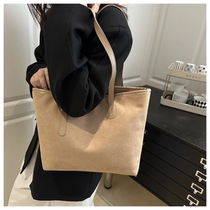 Shoulder view of a large light brown suede tote bag showing its texture and capacity