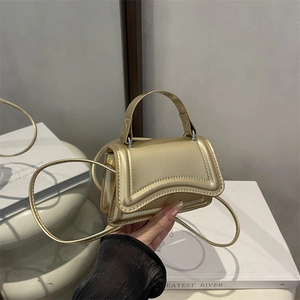 Mini sac à main doré métallisé avec base incurvée et bandoulière amovible