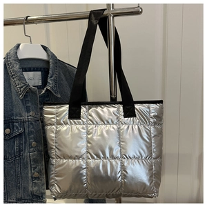 Detail der gesteppten Tragetasche in Silber mit Metallic-Finish und schwarzen Trägern
