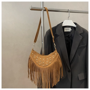 Dettaglio della borsa in pelle scamosciata marrone con borchie e lunghe frange bohémien