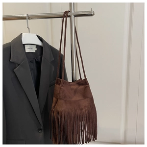 Détail du sac bohème en daim marron foncé avec de longues franges et fines bandoulières
