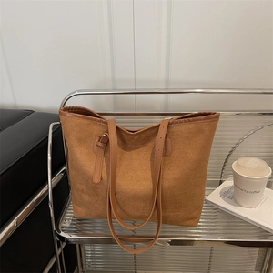 Minimalist brown tote bag with leather straps on a modern shelf, ideal for daily commute